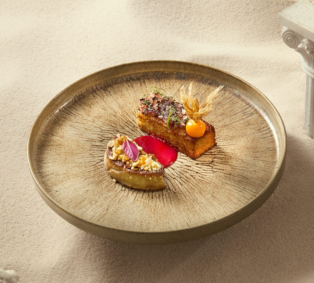 Plated foie gras and beef with physalis on a stoneware plate